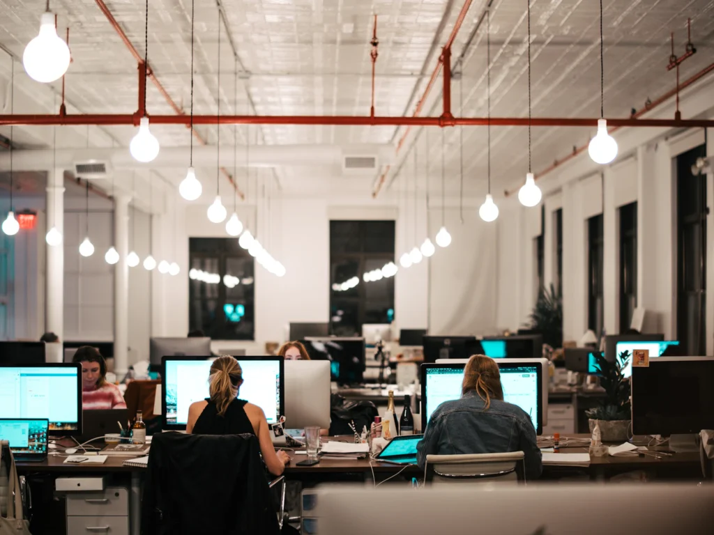 A busy open office in the evening with teams at their screens